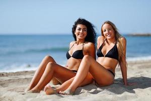 zwei junge Frauen mit schönen Körpern in Badebekleidung an einem tropischen Strand