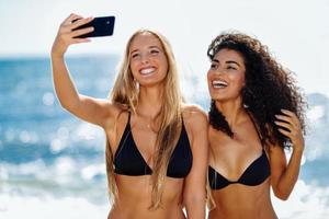 zwei Frauen machen Selfie-Foto mit Smartphone am Strand foto