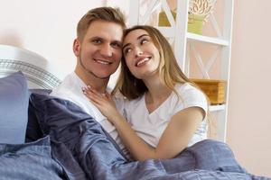 süßes Paar, das sich auf dem Bett entspannt und umarmt, Liebes- und Beziehungskonzept foto