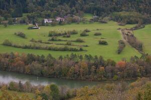 ein Aussicht von ein Feld mit Bäume und ein Fluss foto