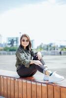 jung schön asiatisch Frau tragen Jacke und schwarz Jeans posieren draußen foto