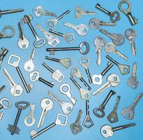 Schlüssel auf blauem Hintergrund. Türschlösser und Tresore für Eigentums- und Hausschutz. verschiedene antike und neue Arten von Schlüsseln. foto