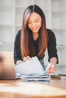 Geschäftsfrau Arbeiten im Stapel von Papier Dateien zum suchen und Überprüfung unvollendet dokumentieren erreicht auf Ordner Papiere beim beschäftigt Arbeit Schreibtisch Büro. foto