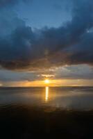 Sonnenuntergang beim das See mit dunkel Wolke. foto