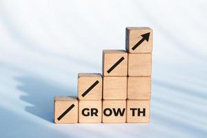 Wachstum oder Geschäftskonzept. Pfeilsymbol und Wort auf Holzwürfeln foto