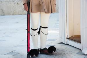 griechischer wächter mit typischer uniform auf dem syntagma-platz trägt seine gtsarouchia, die traditionellen schuhe der evzones, die rot mit einem kleinen Büschel vorne sind. foto