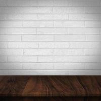 Holztisch mit weißem Backsteinmauerhintergrund foto