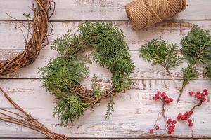 DIY-Weihnachtskranz, der Draufsicht auf hölzernen Hintergrund macht foto