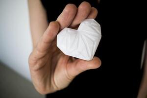 Frau halten Weiß 3d gedruckt Herz. Ideal zum vielfältig Konzept, Liebe und Gesundheit, Dankbarkeit und Nächstenliebe entweder Technologie foto