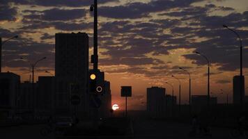 früh Morgen Sonnenaufgang im ein Stadt Straße. Konzept. atemberaubend Rosa und Orange Himmel mit hell rot leuchtenden Sonne steigend über das dunkel Stadt mit Gehen Menschen und Fahren Autos. foto