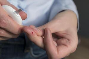 Frau stechend ihr Finger zu prüfen Blut Glucose Niveau mit Glukometer, Prüfung Blut Glucose zum Diabetes foto