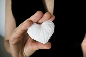 Frau halten Weiß 3d gedruckt Herz. Ideal zum vielfältig Konzept, Liebe und Gesundheit, Dankbarkeit und Nächstenliebe entweder Technologie foto
