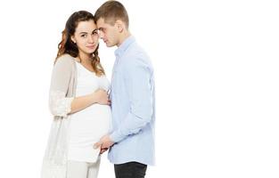 Schöne schwangere Frau und ihr gutaussehender Ehemann lächeln, während sie Zeit miteinander verbringen Baby geboren foto