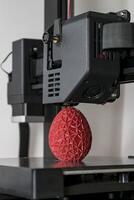 schließen oben von ein 3d Drucker Drucken ein rot polygonal Ei foto