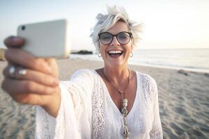 ai generativ glücklich Senior Frau nehmen Selfie mit Clever Handy, Mobiltelefon Telefon beim das Strand älter weiblich genießen Sommer- Ferien Sommer Ferien reifen Menschen und Reisen Konzept foto