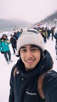 ai generativ jung Mann tragen Winter Kleider nehmen Selfie Bild im Winter Schnee Berg glücklich Kerl mit Rucksack Wandern draußen Erholung Sport und Menschen Konzept foto