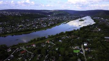 arial Aussicht von ein klein Stadt, Dorf gekreuzt durch ein Fluss mit ein Brücke. Clip. ökologisch Ort, Leben im das Landschaft. foto