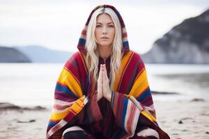 ai generiert Porträt schön Ruhe entspannt blond europäisch Frau Dame Ozean Strand bunt Decke üben Meditation Yoga Lotus Pose Hände mental Gesundheit Seele spirituell Zen sich ausruhen Wellness foto