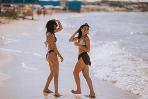 zwei ziemlich jung Frau haben Spaß auf das Strand foto