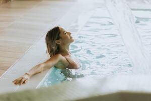 jung Frau entspannend im das Innen- Schwimmen Schwimmbad foto