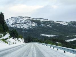 Fahren durch schneeweiße Straße und Landschaft in Norwegen. foto