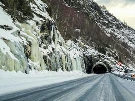 gefrorene vereiste Wasserfälle und dunkle Tunnel, Straßen von Norwegen. foto