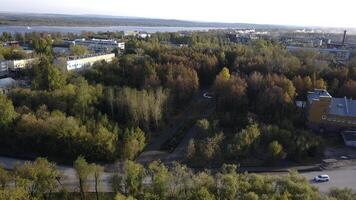 oben Aussicht von Stadt auf Hintergrund von Fluss und Herbst Wald. Clip. Landschaft von Stadt, Dorf mit Bäume auf Herbst sonnig Tag. Stadt, Dorf durch Fluss im Wald Bereich im Herbst foto