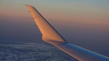 das Flugzeug Flügel Aussicht sah von das fliegend Flugzeug Fenster mit das Sonnenuntergang Sonnenlicht auf es foto