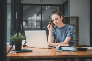 jung Geschäftsfrau Denken Über etwas während Sitzung Vorderseite öffnen tragbar Laptop Computer lesen Email von Klient, lange Std von Arbeit Konzept foto