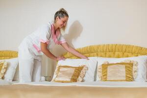 schön Hotel Maid Herstellung Bett im ein Zimmer. foto