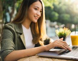 ai generiert asiatisch Frau Arbeiten mit Computer Notizbuch beim ein Kaffee Geschäft foto