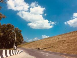 ländlich Land Straße inmitten Grün Bäume foto