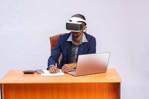 gut aussehend afrikanisch Mitarbeiter mit virtuell Wirklichkeit Brille im Büro foto