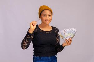 glücklich jung Frau halten Geld und Anerkennung Karte. foto