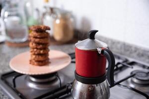 frisch bereit Kekse im das Küche, serviert auf ein Teller Nächster zu ein Kaffee Hersteller. foto