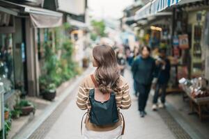 Frau Tourist Besuch im Enoshima Insel, Fujisawa, Kanagawa, Japan. glücklich Reisender Besichtigung Enoshima Schrein. Wahrzeichen und Beliebt zum Touristen Attraktion in der Nähe von Tokio. Reise und Ferien Konzept foto