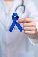 März kolorektal Krebs Bewusstsein Monat, Arzt mit dunkel Blau Band zum unterstützen Menschen Leben und Erkrankung. Gesundheitspflege, hoffen und Welt Krebs Tag Konzept foto