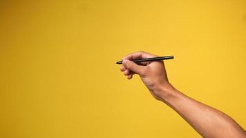 Hand von Mann halten Stift auf Gelb Hintergrund foto