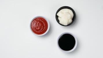 drei Saucen Ketchup Mayonnaise, Süss Soja Soße und Chili Soße im schwarz Schüssel isoliert auf Weiß Hintergrund foto