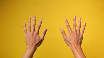 schließen oben von zwei Hände von ein des Mannes Hand auf ein Gelb Hintergrund foto