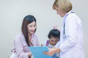 Mutter und Kind beim ein medizinisch Untersuchung beim Krankenhaus oder Klinik, weiblich Arzt reden mit Tochter und Mutter im Krankenhaus foto