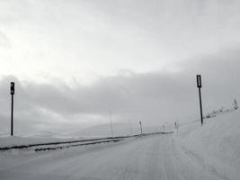 Fahren durch verschneite Straße und Landschaft in Norwegen. foto