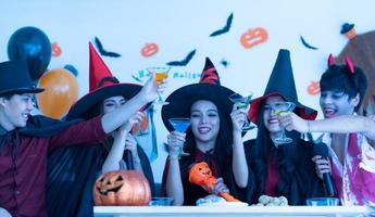 asiatische junge leute in kostümen feiern an halloween party foto