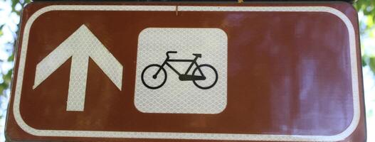 Nahansicht von Zyklus Symbol auf ein braun Hintergrund. das Symbol zeigt an ein Straße oder Fahrbahn gewidmet zu Radfahrer foto