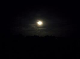 das Mond ist leuchtenden hell im das dunkel Himmel foto