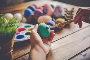 jung Mädchen Gemälde Ostern Eier zum Osterzeit beim Zuhause foto