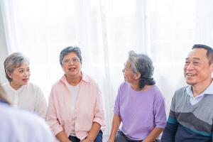 Senior Frauen und männlich Sitzung auf Bank. älter Menschen sind Hören und genießen Treffen Fokus Gruppe beim Leben Zimmer. froh sorglos im Ruhestand Senior freunde genießen Entspannung beim fast heim. foto