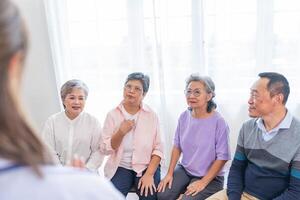 Senior Frauen und männlich Sitzung auf Bank. älter Menschen sind Hören und genießen Treffen Fokus Gruppe beim Leben Zimmer. froh sorglos im Ruhestand Senior freunde genießen Entspannung beim fast heim. foto