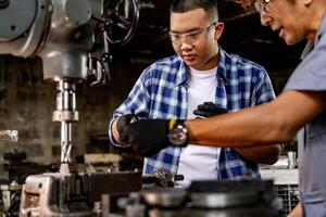 asiatisch Arbeiter im Produktion Pflanze Bohren beim Maschine. Fachmann Arbeiter in der Nähe von Bohren Maschine auf Fabrik. Fertigstellung Metall Arbeiten intern Stahl Oberfläche auf Drehbank Schleifer Maschine mit fliegend Funken. foto