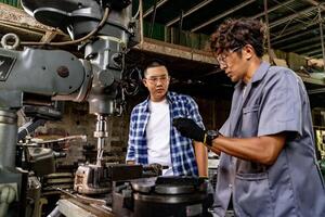 asiatisch Arbeiter im Produktion Pflanze Bohren beim Maschine. Fachmann Arbeiter in der Nähe von Bohren Maschine auf Fabrik. Fertigstellung Metall Arbeiten intern Stahl Oberfläche auf Drehbank Schleifer Maschine mit fliegend Funken. foto